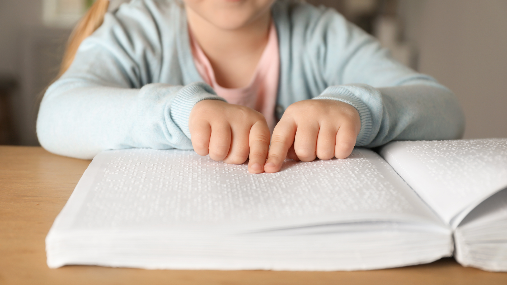 Persona che legge un libro in braille utilizzando il tatto per percepire i caratteri.